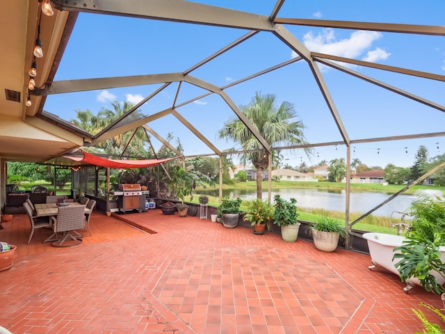 view of patio with a water view, a lanai, and a grill