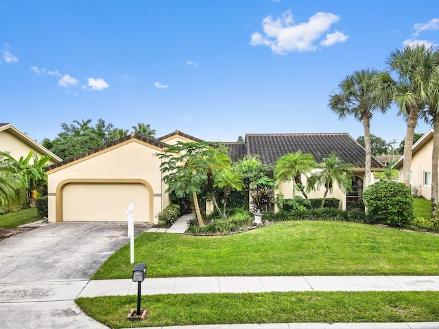 mediterranean / spanish home with a garage and a front lawn