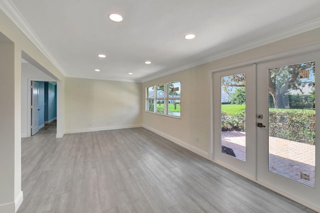 empty room featuring light hardwood / wood-style floors, crown molding, and french doors