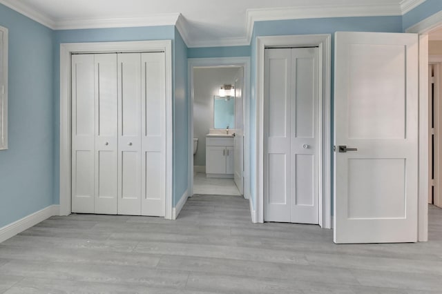 unfurnished bedroom featuring ornamental molding, light hardwood / wood-style floors, and connected bathroom