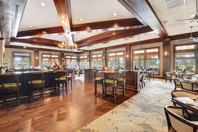 bar featuring beamed ceiling, hardwood / wood-style floors, pendant lighting, and a healthy amount of sunlight