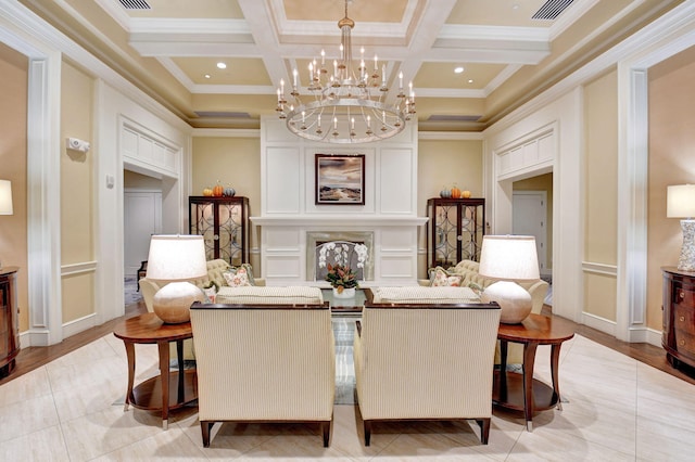 sitting room with ornamental molding, a chandelier, coffered ceiling, and light wood-type flooring