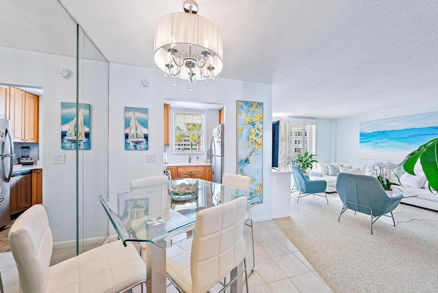 dining room featuring sink, light carpet, a textured ceiling, and an inviting chandelier