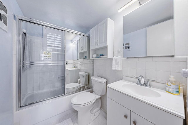 full bathroom featuring shower / bath combination with glass door, tile walls, toilet, vanity, and tile patterned flooring