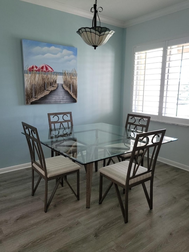 dining area with hardwood / wood-style floors, a wealth of natural light, and crown molding