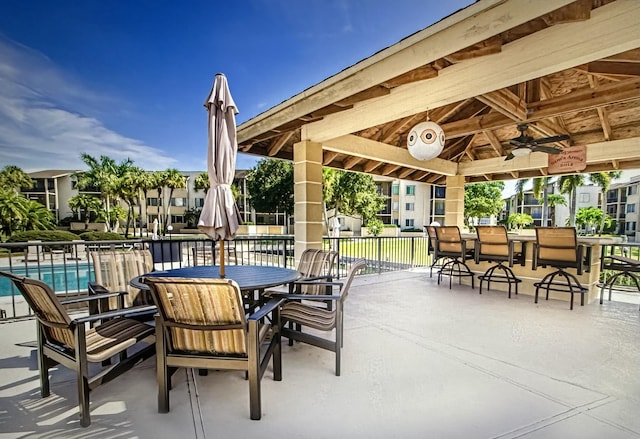 view of patio / terrace featuring a gazebo, ceiling fan, and a community pool