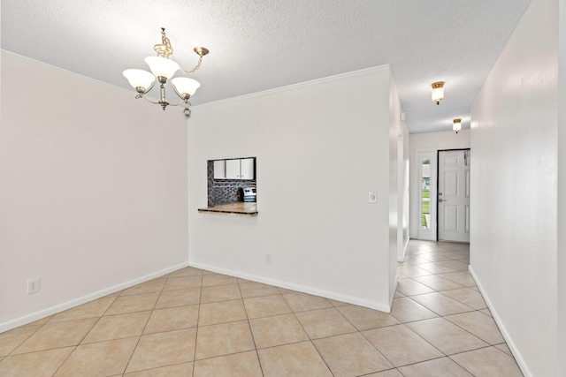 unfurnished room featuring a notable chandelier, crown molding, and light tile patterned floors