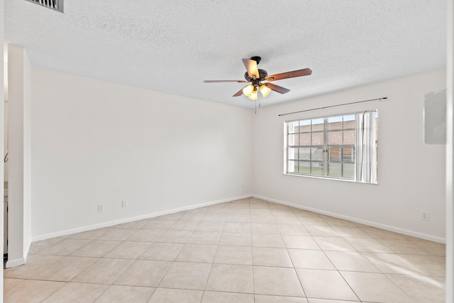 empty room featuring ceiling fan, a textured ceiling, and light tile patterned floors