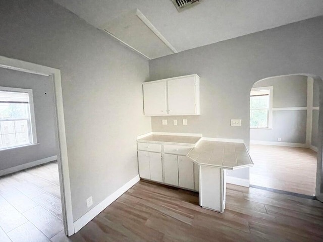 kitchen featuring light hardwood / wood-style floors, kitchen peninsula, and white cabinets