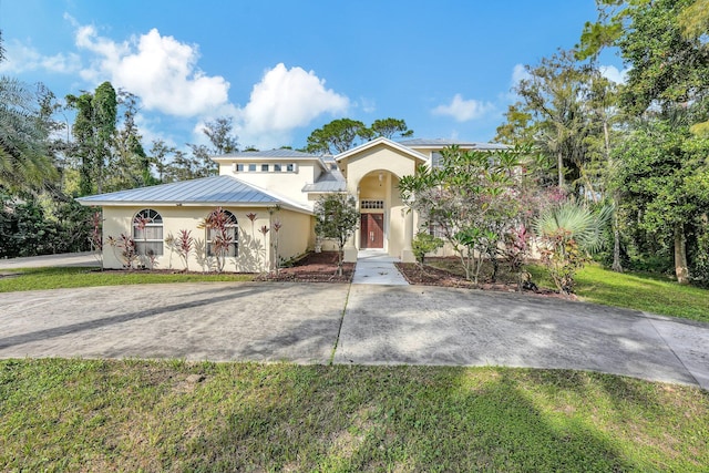 mediterranean / spanish home with a front yard