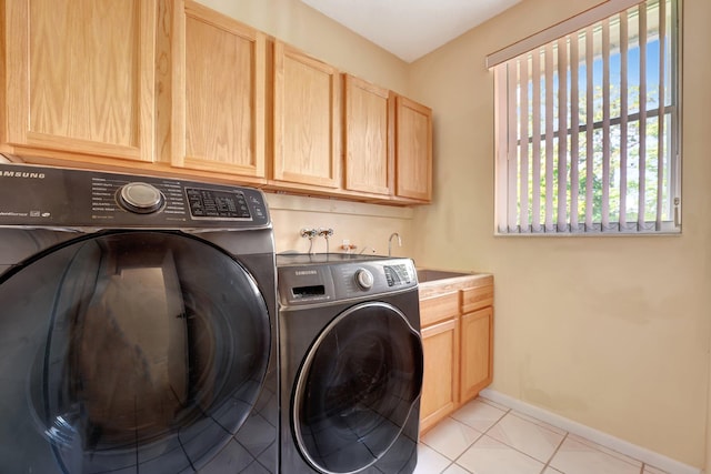 laundry area with light tile patterned flooring, sink, cabinets, and washing machine and clothes dryer