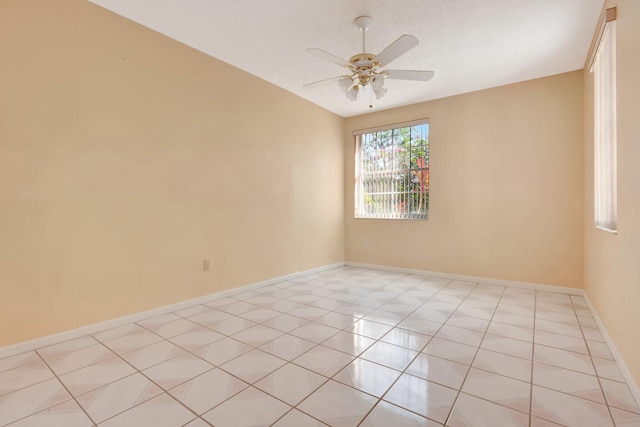 tiled spare room with a textured ceiling and ceiling fan