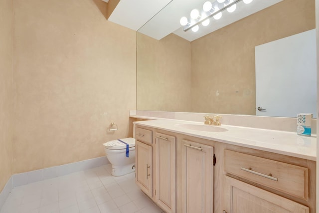 bathroom featuring toilet, vanity, and tile patterned flooring