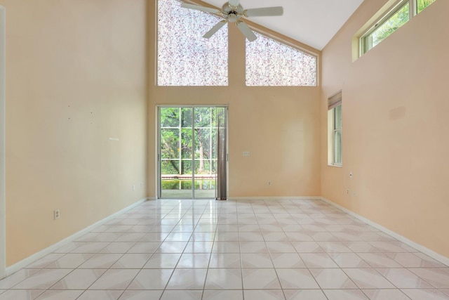 unfurnished room with a healthy amount of sunlight, high vaulted ceiling, and light tile patterned floors