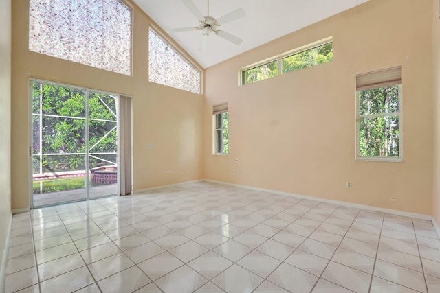 tiled empty room with high vaulted ceiling, plenty of natural light, and ceiling fan