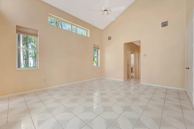 empty room with light tile patterned floors, high vaulted ceiling, and ceiling fan