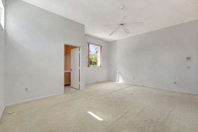 empty room featuring a textured ceiling, light colored carpet, and ceiling fan