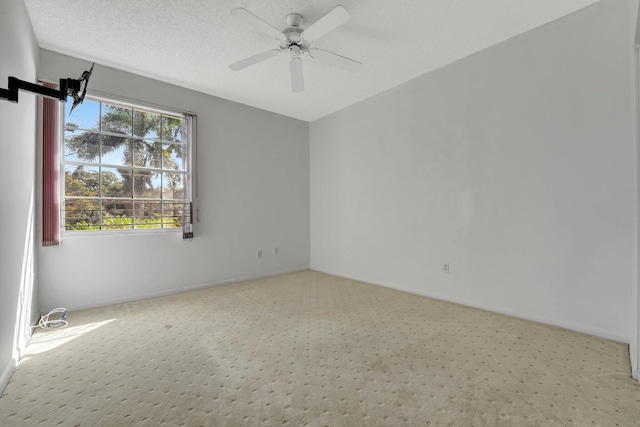 carpeted spare room with a textured ceiling and ceiling fan