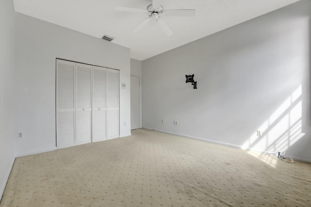 unfurnished bedroom featuring carpet floors, a closet, and ceiling fan