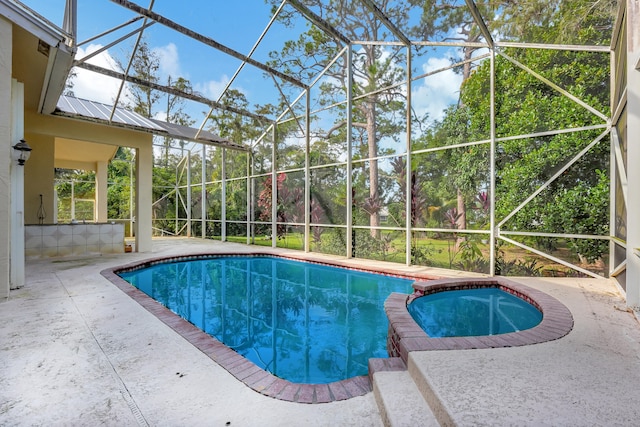 view of pool featuring an in ground hot tub, a patio, and glass enclosure