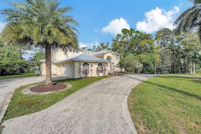 view of front of house with a garage and a front lawn