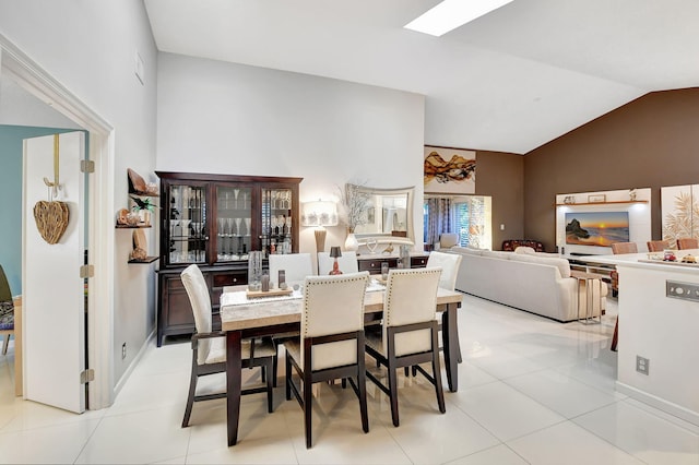 dining area with light tile patterned floors and high vaulted ceiling