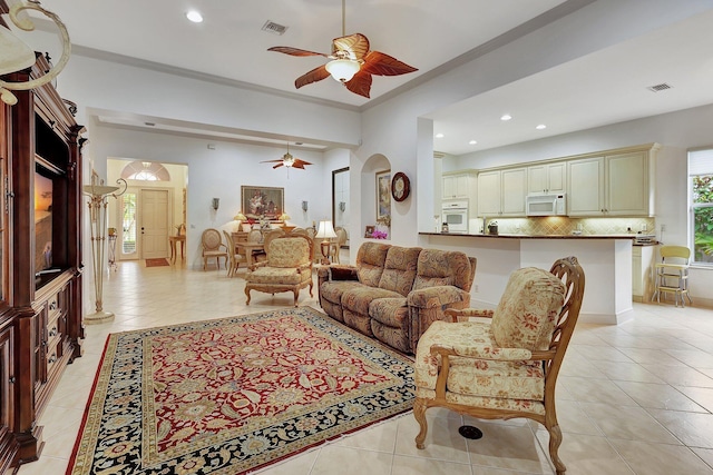 tiled living room with crown molding and ceiling fan