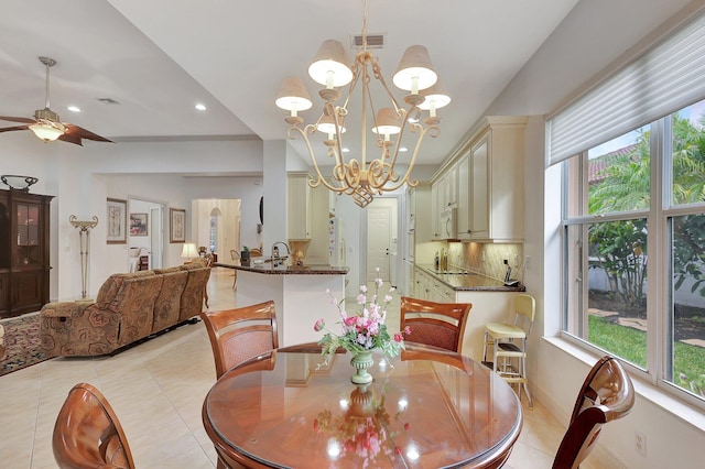 tiled dining room with plenty of natural light and ceiling fan with notable chandelier