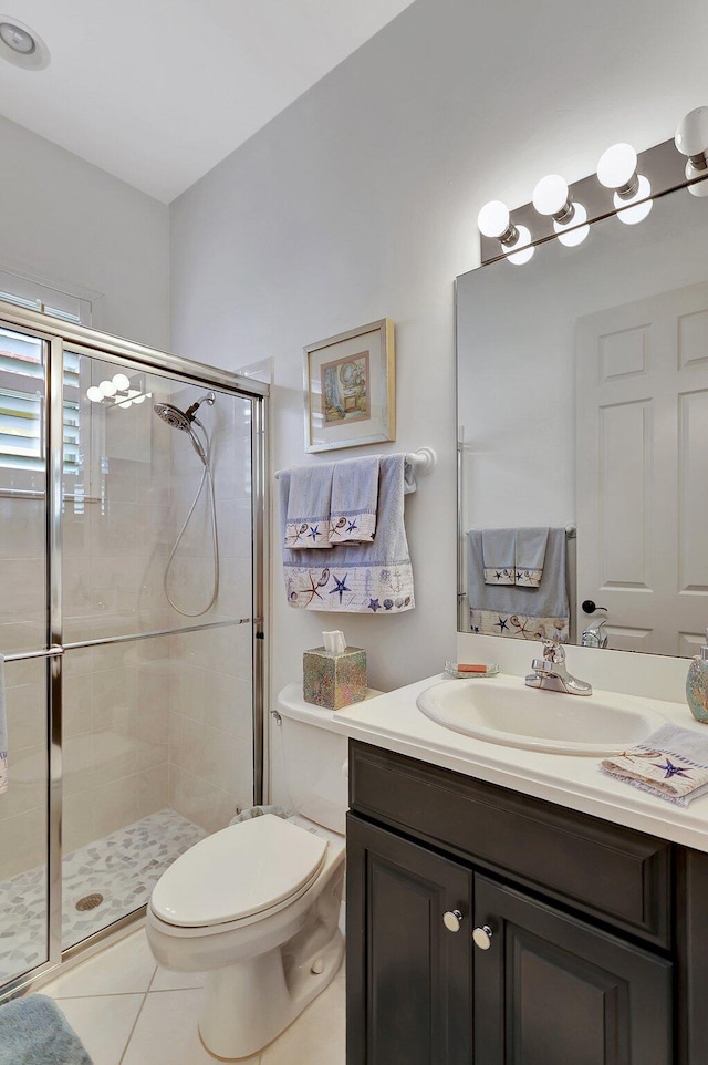 bathroom featuring vanity, tile patterned floors, toilet, and an enclosed shower