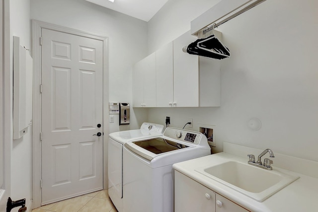 laundry room featuring sink, light tile patterned flooring, washer and dryer, and cabinets