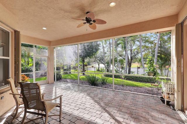 sunroom / solarium with a healthy amount of sunlight and ceiling fan