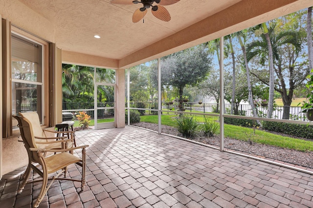 unfurnished sunroom featuring ceiling fan