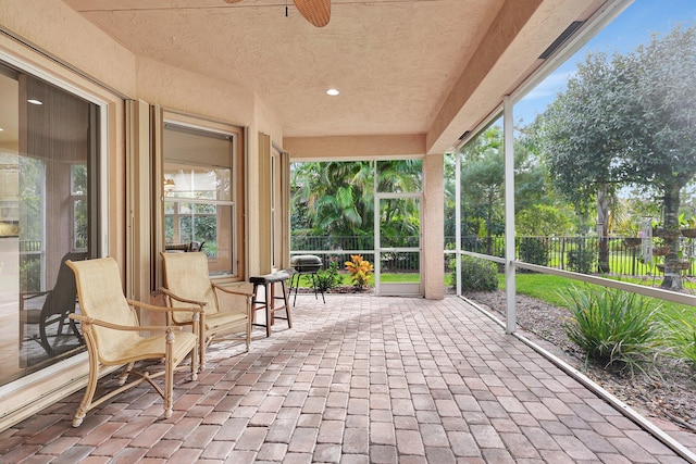 unfurnished sunroom with plenty of natural light and ceiling fan