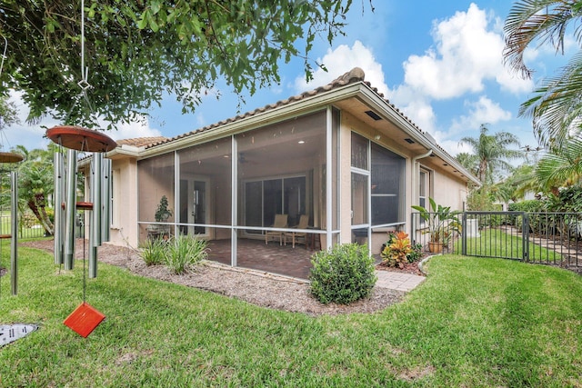 view of side of property with a sunroom and a lawn