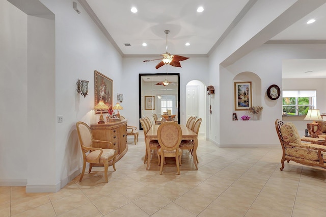 tiled dining area featuring crown molding and ceiling fan