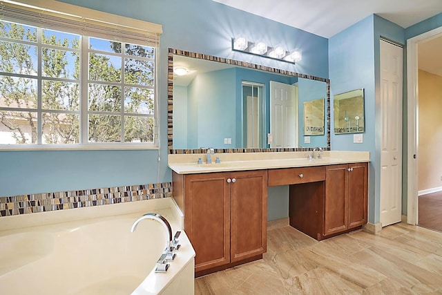 bathroom featuring a wealth of natural light, vanity, and a bathing tub