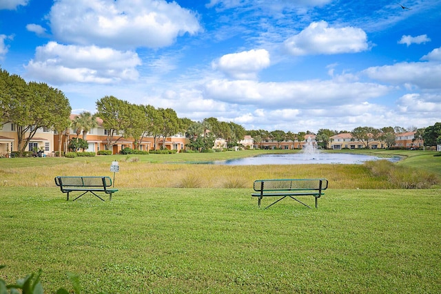 view of property's community featuring a water view and a yard