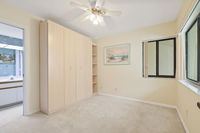 unfurnished bedroom with a closet, ceiling fan, light carpet, and sink