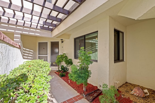 view of exterior entry featuring a pergola