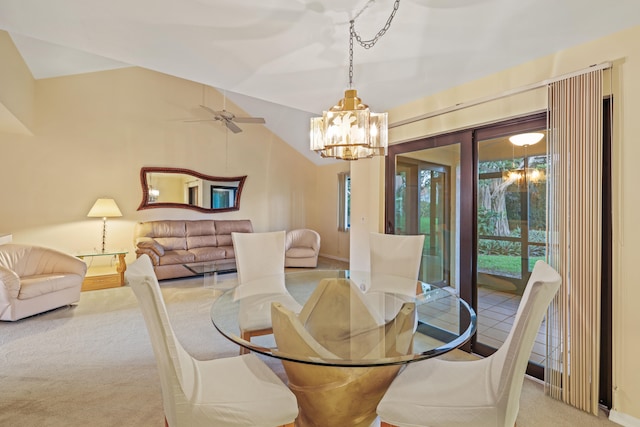 carpeted dining room with lofted ceiling and ceiling fan with notable chandelier