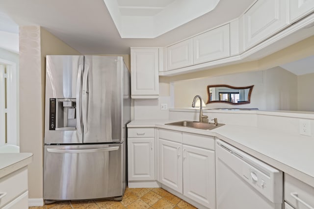 kitchen with white cabinetry, dishwasher, sink, and stainless steel fridge