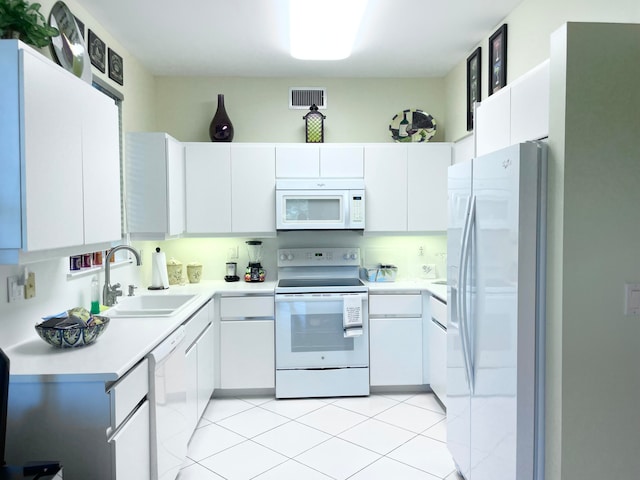 kitchen with white appliances, light tile patterned floors, white cabinetry, and sink