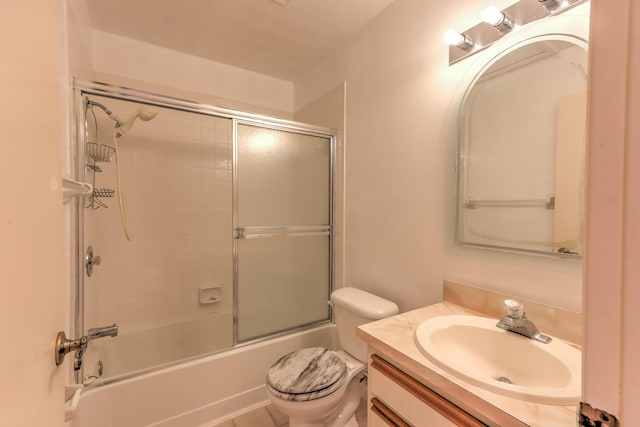 full bathroom featuring vanity, shower / bath combination with glass door, and toilet