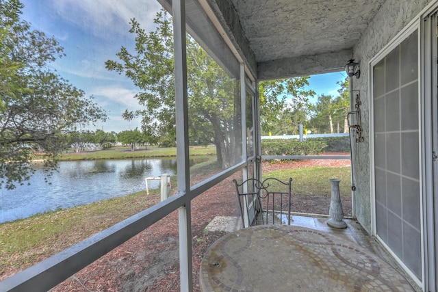 unfurnished sunroom with a water view