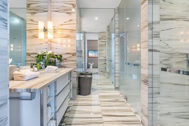 bathroom featuring tile walls, vanity, and walk in shower