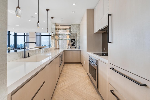 kitchen with light parquet flooring, oven, sink, pendant lighting, and white refrigerator