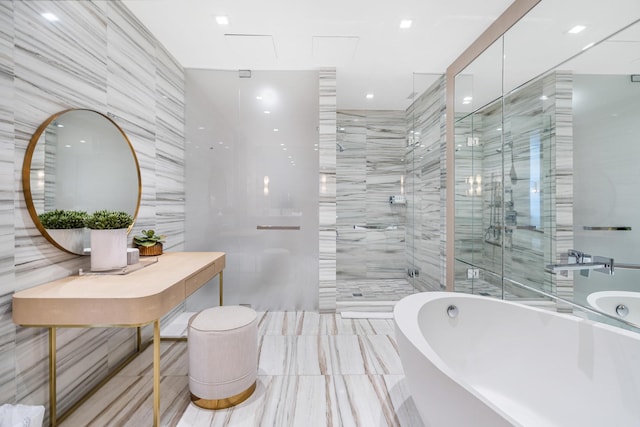 bathroom with tile walls and separate shower and tub