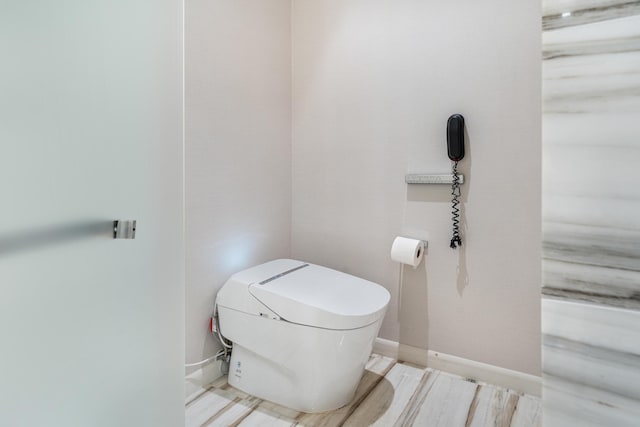 bathroom featuring toilet and wood-type flooring