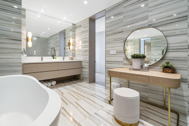 bathroom with vanity, tile walls, and a tub