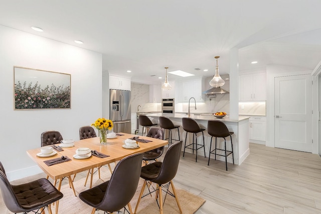 dining room featuring light wood-type flooring and sink